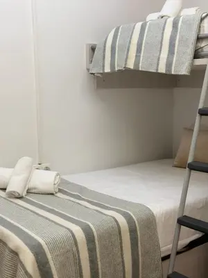 a bedroom with two bunk beds with a striped blanket at Dudu life in Barcelona