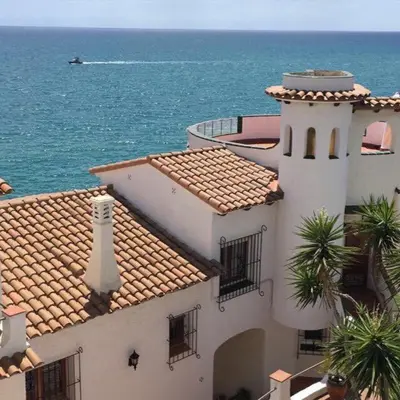 a building with a lighthouse on top of it next to the ocean at Loft espectacular vista al mar in Sitges