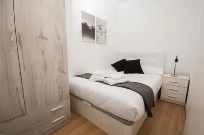 a bedroom with a bed and a wooden cabinet at Casa a pasos de Las Ramblas in Barcelona