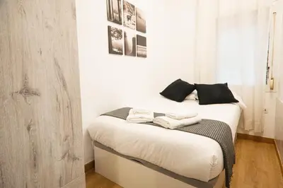 a bedroom with a bed with two towels on it at Casa a pasos de Las Ramblas in Barcelona