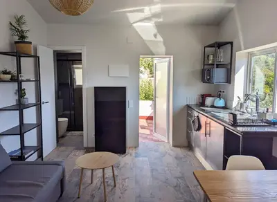 a kitchen and living room with a couch and a table at Apartamento en medio de la naturaleza, con fantásticas vistas in Sant Cugat del Vallès