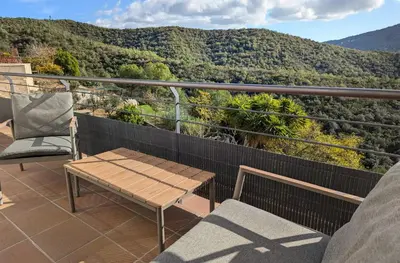 a balcony with a bench and a view of a mountain at Apartamento en medio de la naturaleza, con fantásticas vistas in Sant Cugat del Vallès