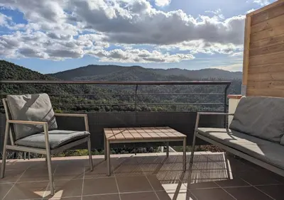 a balcony with two chairs and a table and a view at Apartamento en medio de la naturaleza, con fantásticas vistas in Sant Cugat del Vallès