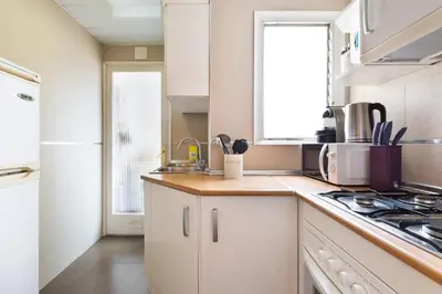 a kitchen with white cabinets and a sink and a window at Stay U-nique Apartments Rambla Catalunya in Barcelona