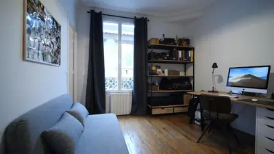 a living room with a desk with a computer and a couch at Bien en exclusivité in El Prat de Llobregat