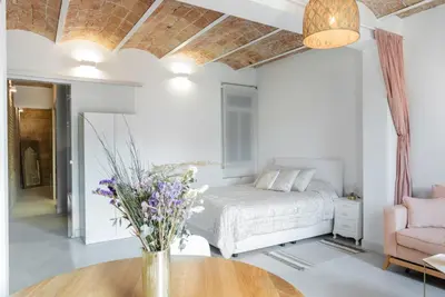 a bedroom with a bed and a table with flowers on it at Magic Apartment with Private Terrace in Barcelona