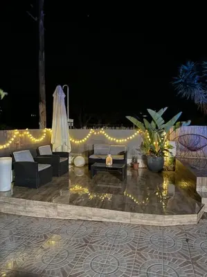 a patio with furniture and a string of lights at Casa con piscina uso privado in Cunit