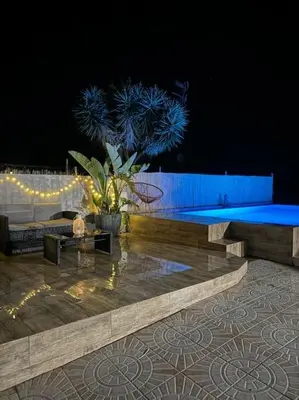 a stage with two benches and a plant at night at Casa con piscina uso privado in Cunit
