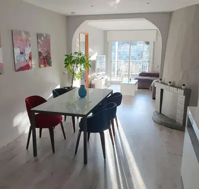 a living room with a dining room table and chairs at Casa con piscina uso privado in Cunit