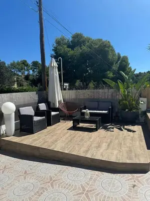a patio with furniture and an umbrella and a table at Casa con piscina uso privado in Cunit