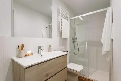 a white bathroom with a sink and a shower at Casa Ciudadela in Barcelona