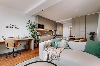 a living room with a couch and a kitchen at Casa Ciudadela in Barcelona