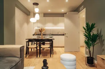 a kitchen and living room with a table in a room at Casa Castaner in Barcelona