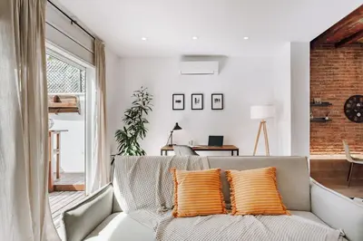 a living room with a couch with orange pillows at Casa Narciso in Barcelona