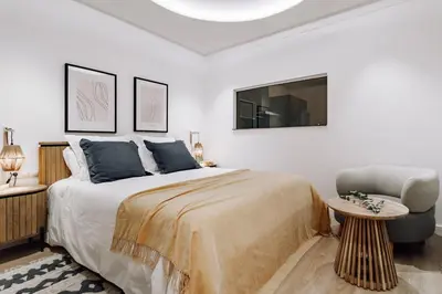 a bedroom with a large bed and a chair at Casa Narciso in Barcelona