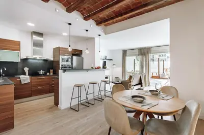 a kitchen and dining room with a wooden table and chairs at Casa Narciso in Barcelona