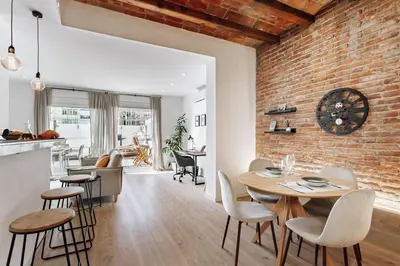 a dining room and living room with a brick wall at Casa Narciso in Barcelona