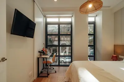 a bedroom with a bed and a desk and a tv at Casa Duran in Barcelona