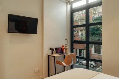 a bedroom with a desk and a tv and a window at Casa Duran in Barcelona