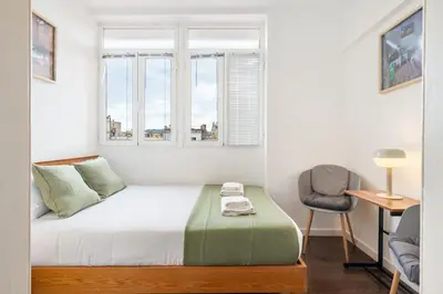 a small bedroom with a bed and a window at Enrique Granados Apartment in Barcelona