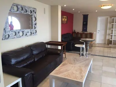 a living room with a black leather couch and a table at House Seaviews Barcelona 22Km in Cabrils