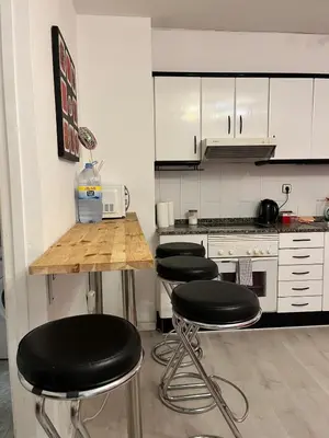 a kitchen with four black bar stools and a counter at Triumf in Barcelona