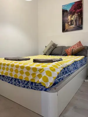 a bed with a yellow and white blanket on it at Triumf in Barcelona