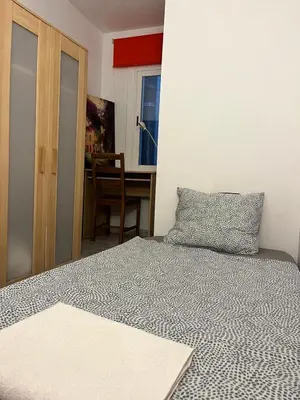 a bedroom with a bed and a table and a desk at Triumf in Barcelona