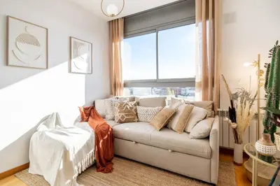 a living room with a couch and a window at Penthouse with Private Terrace & Pool Access in Cornellà de Llobregat