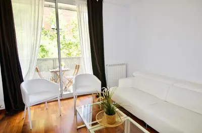 a living room with a white couch and two white chairs at Glasir Homes Barcelona in Barcelona