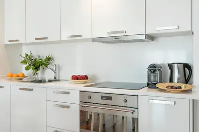a white kitchen with white cabinets and a sink at Glasir Homes Barcelona in Barcelona