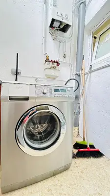 a washing machine in a room with a broom at MaiFamilyBCN-Cómodo Y Para familia Y Metro Cercano in Badalona