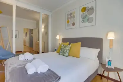 a bedroom with a large white bed with two towels at Sant Joan entresol in Barcelona