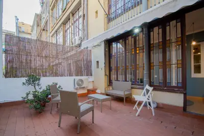 a patio with chairs and a bench in a building at Sant Joan entresol in Barcelona
