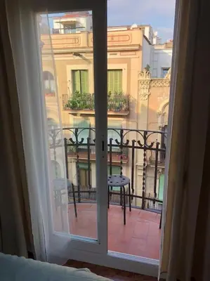 an open window with a view of a balcony at Plaza España - Central and quiet 2BR for couples, families and events in Barcelona