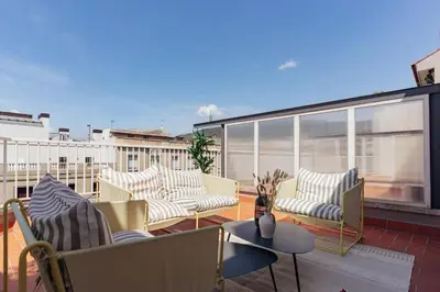 a balcony with couches and chairs on a roof at Casa Gavina in Barcelona