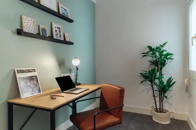 an office with a desk with a laptop and a chair at Casa Gavina in Barcelona