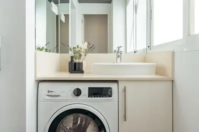 a bathroom with a washing machine and a sink at Casa Gavina in Barcelona