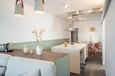 a kitchen and living room with a table and a counter at Casa Gavina in Barcelona