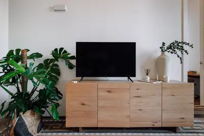 a television on a wooden dresser in a living room at Casa Jordi in Barcelona