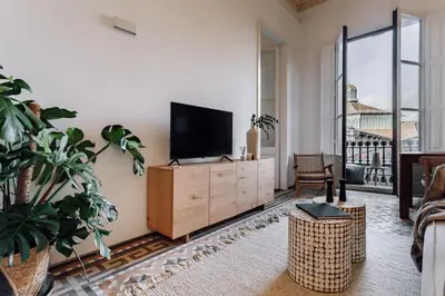 a living room with a flat screen tv on a wooden cabinet at Casa Jordi in Barcelona