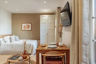 a bedroom with a bed and a table with a television at Casa Laietana in Barcelona