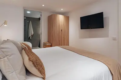 a bedroom with a white bed and a flat screen tv at Casa Lennon in Barcelona