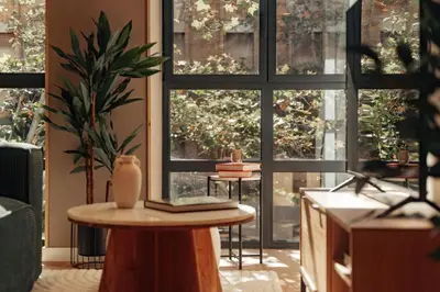 a room with large windows and a table with a plant at Casa Macaya in Barcelona