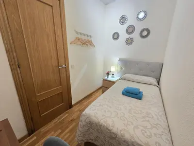 a bedroom with a bed with a colorful comforter at Habitaciones acogedoras en Aragón in Barcelona
