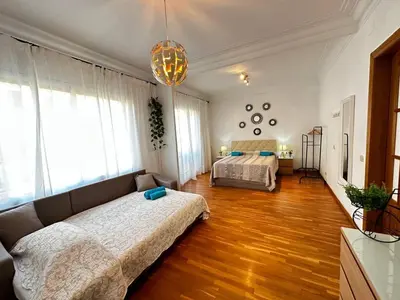 a small bedroom with two beds and a wooden door at Habitaciones acogedoras en Aragón in Barcelona