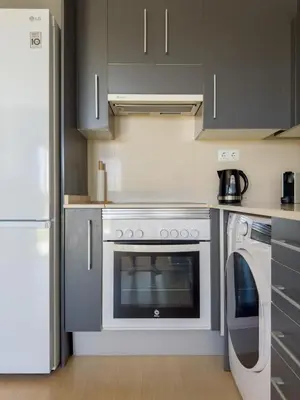 a kitchen with a white stove and a dishwasher at Apartamento en la playa in Castelldefels