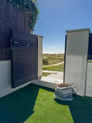 a door on the side of a building with grass at Apartamento en la playa in Castelldefels
