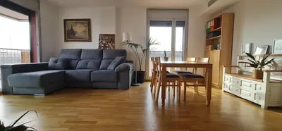 a living room with a blue couch and a table at Pis molt cèntric amb vistes in Terrassa