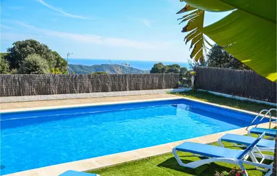 a swimming pool with two chairs and a fence at Lovely Home In St Cebrià De Vallalta in Sant Cebrià de Vallalta